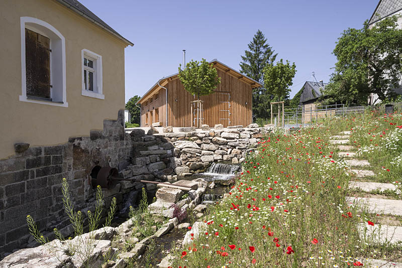 Renaturierter Bachlauf mit Dorfhaus